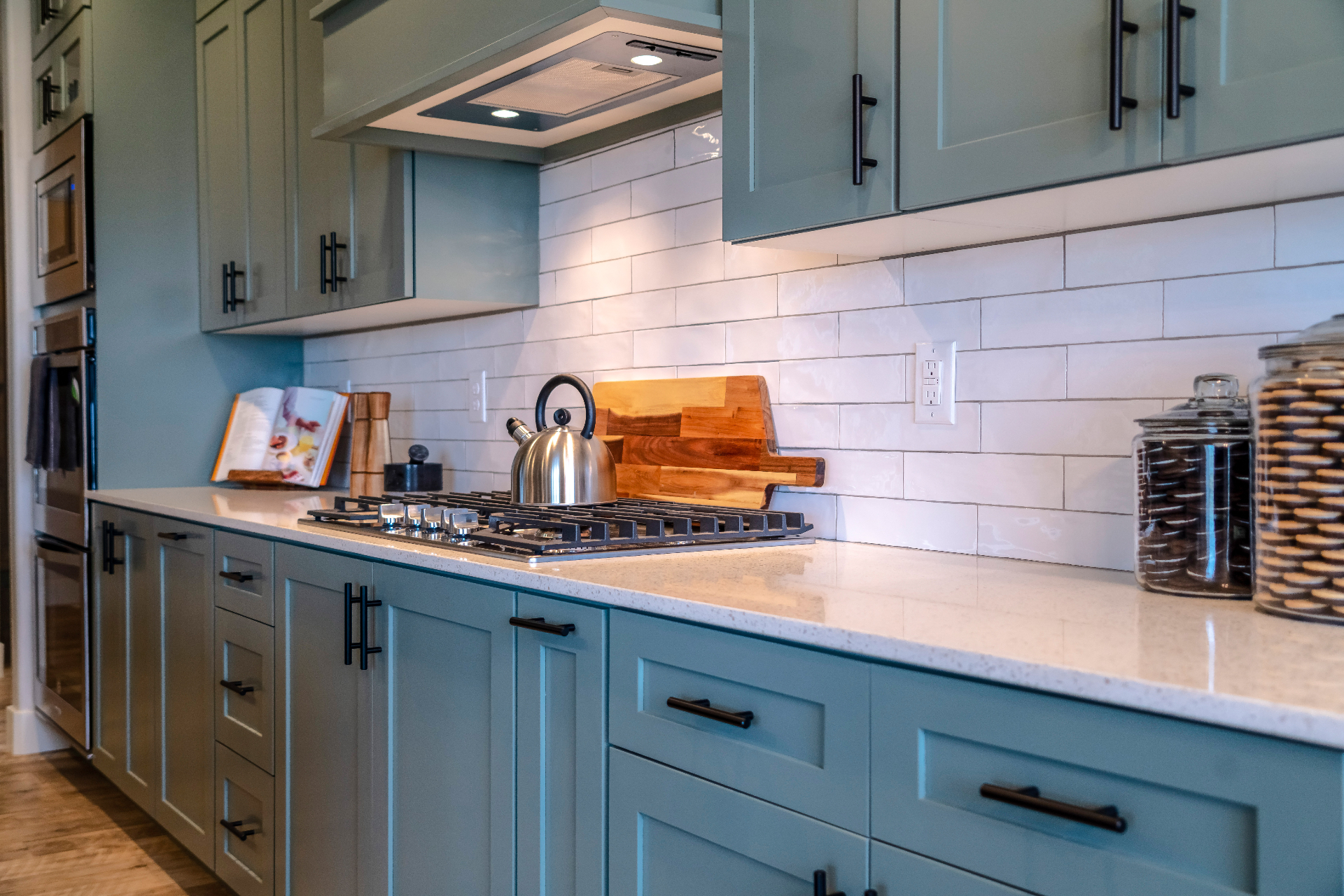 Sage green shaker cabinetry with quartz countertops by KCL